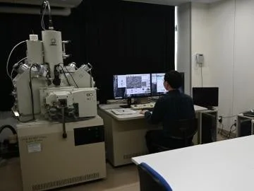 研究室で研究者が走査型電子顕微鏡を操作している様子