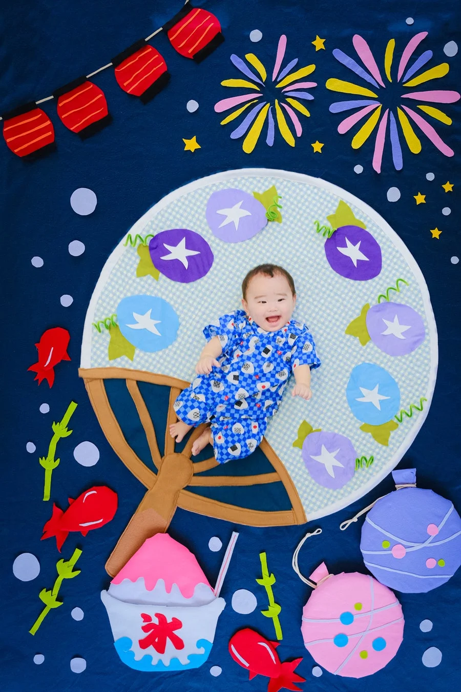 夏祭りテーマのおひるねアートで楽しそうな赤ちゃん