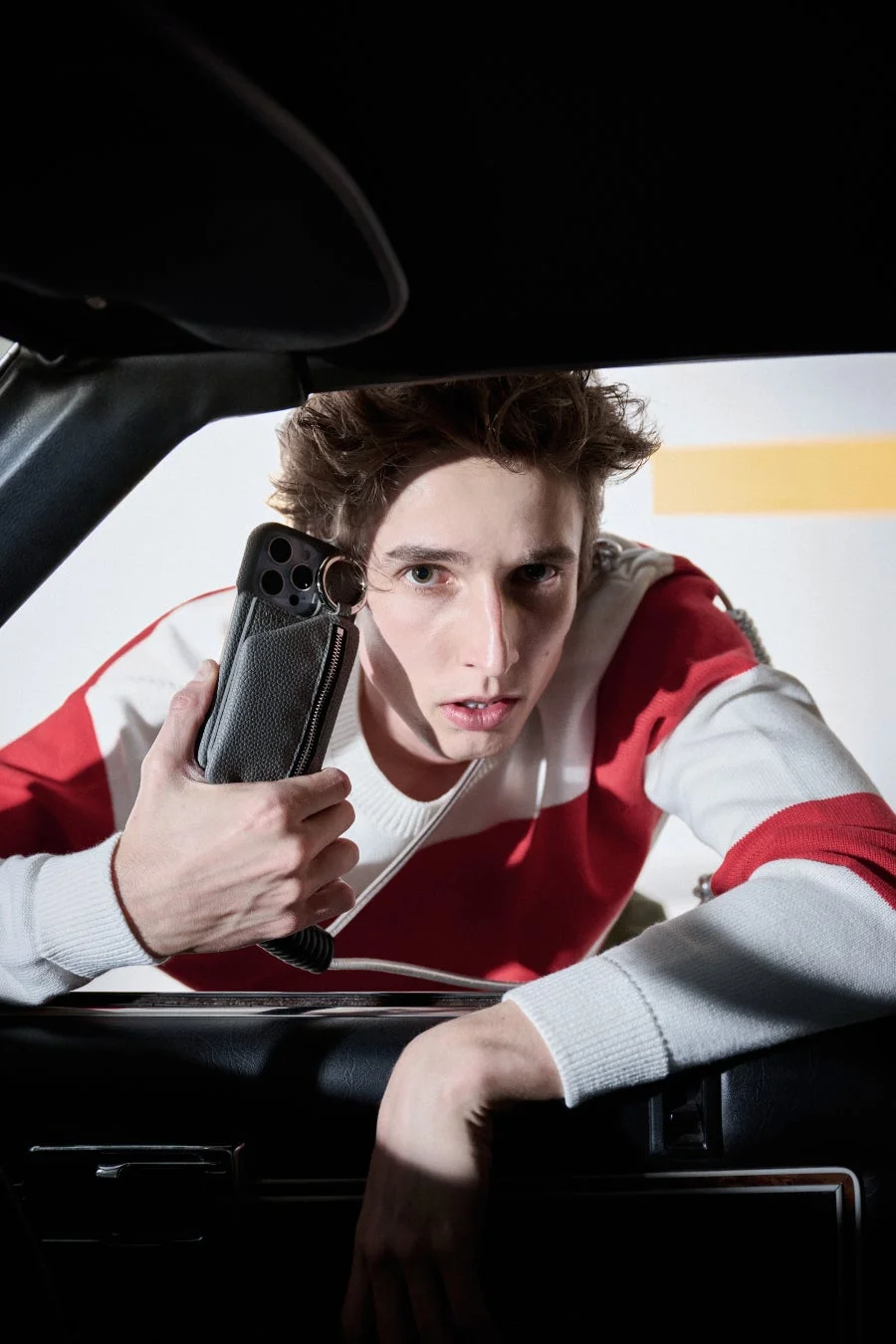 男性が黒い革のスマホケースを装着したスマートフォンを構え