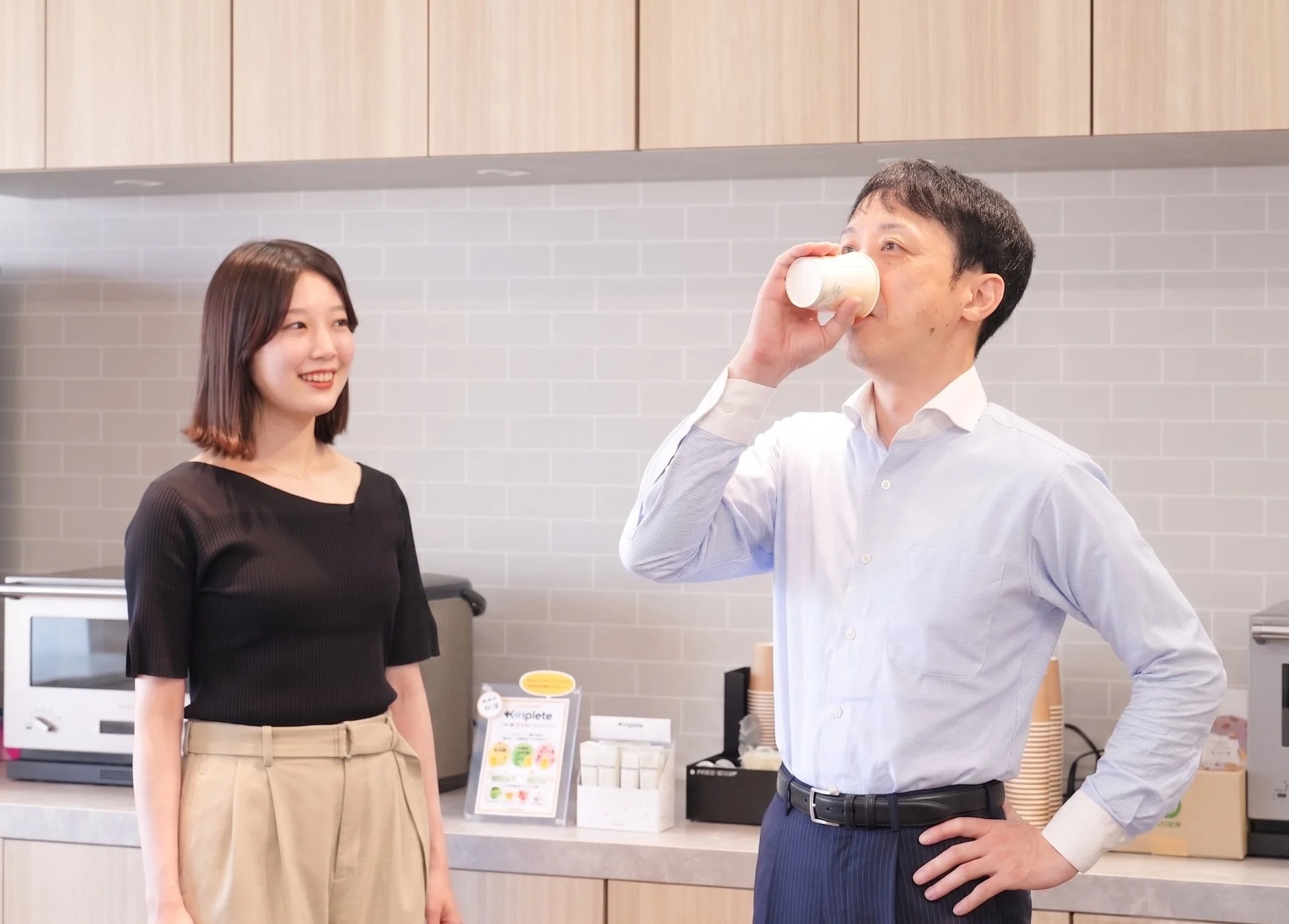 オフィスで飲み物を飲むビジネスパーソン