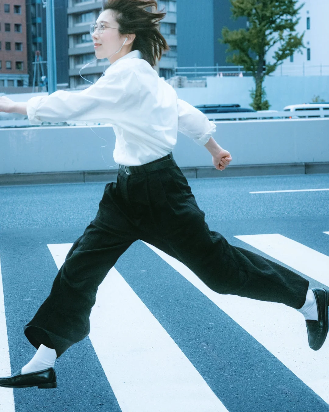 都市の横断歩道を軽やかに駆け抜ける女性