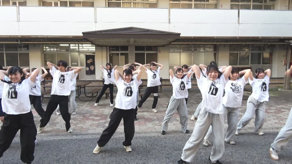 校庭でダンス練習をする学生たち