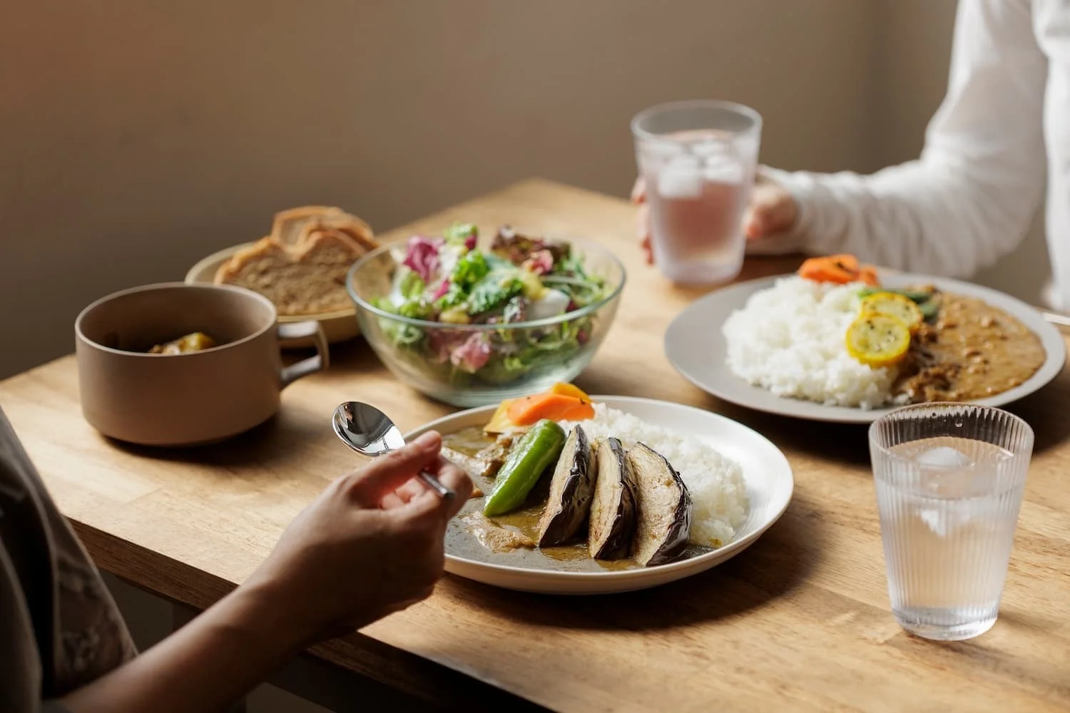 食卓でカレーを食べる人々