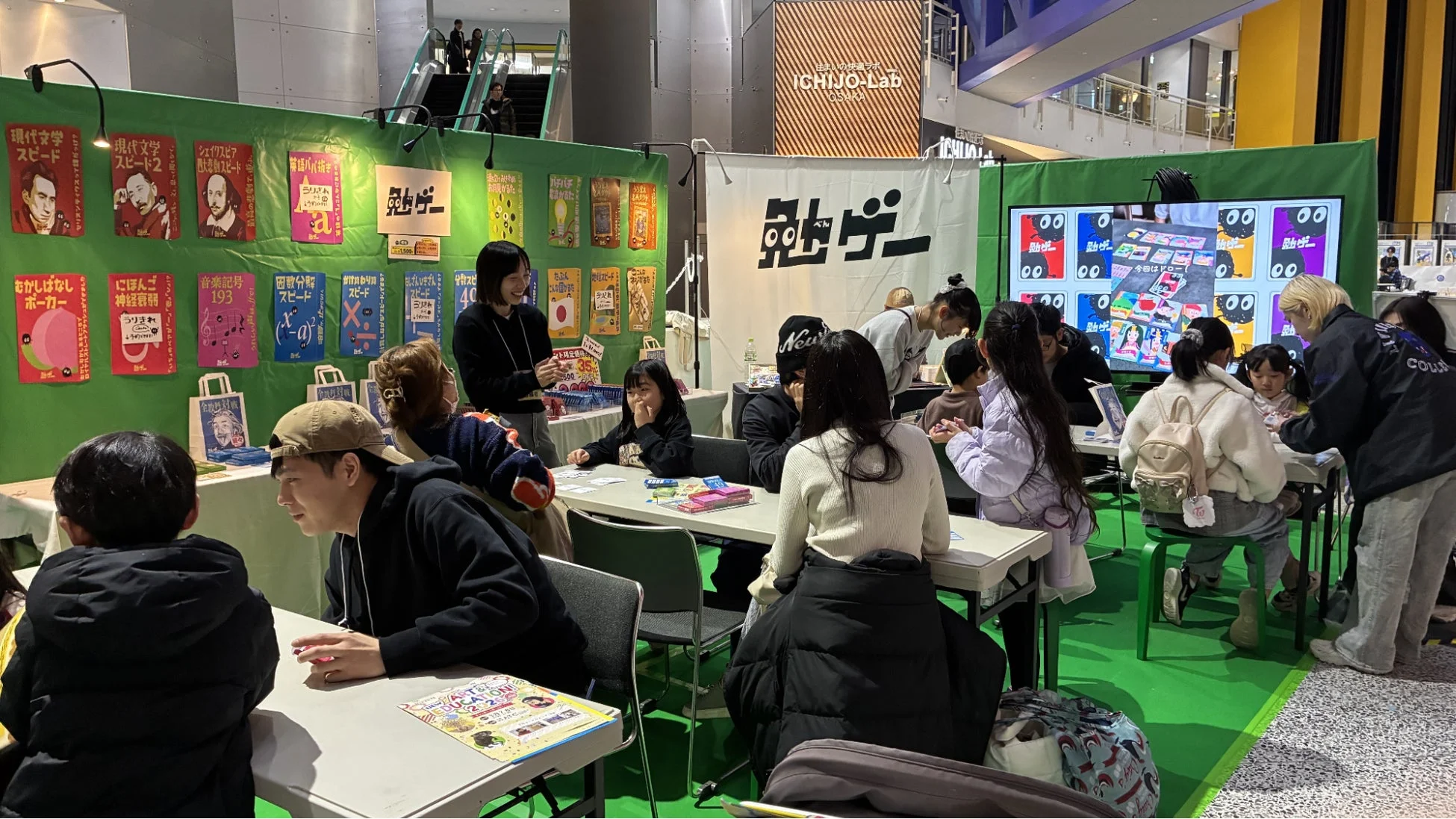 屋内会場で勉ゲーを体験する親子連れの様子
