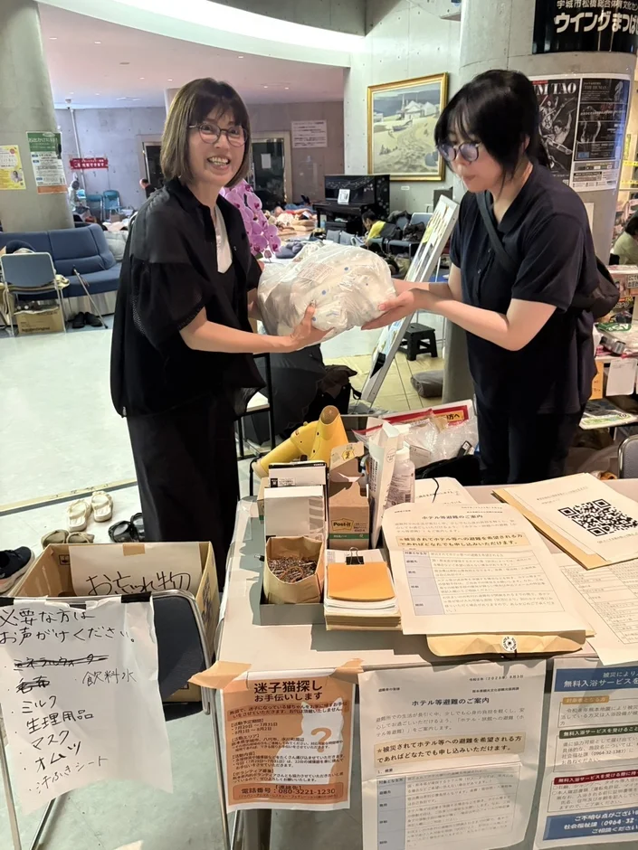 避難所で支援物資リストを見る女性たち