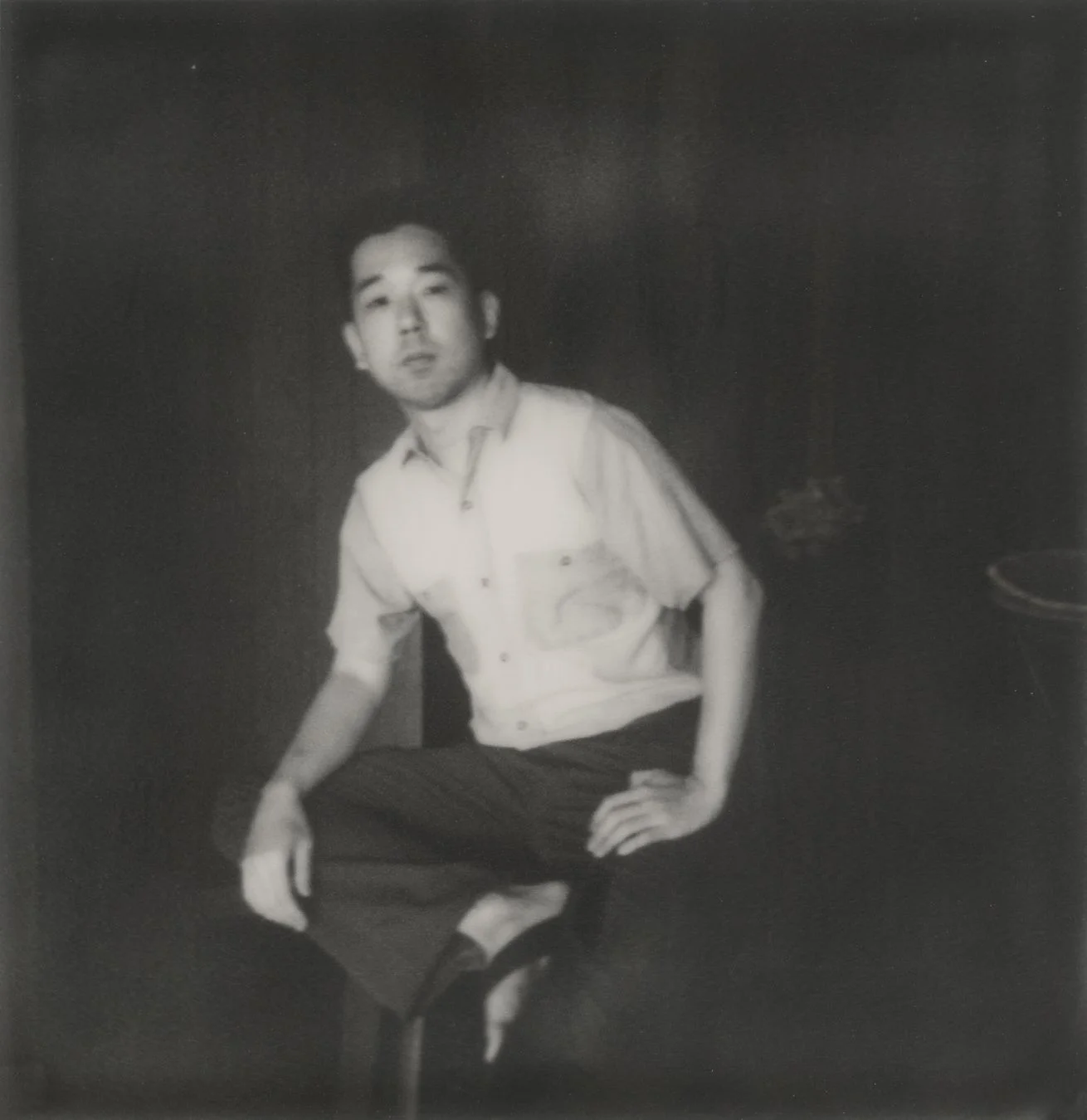 白黒写真に写る、カジュアルな服装のアジア人男性