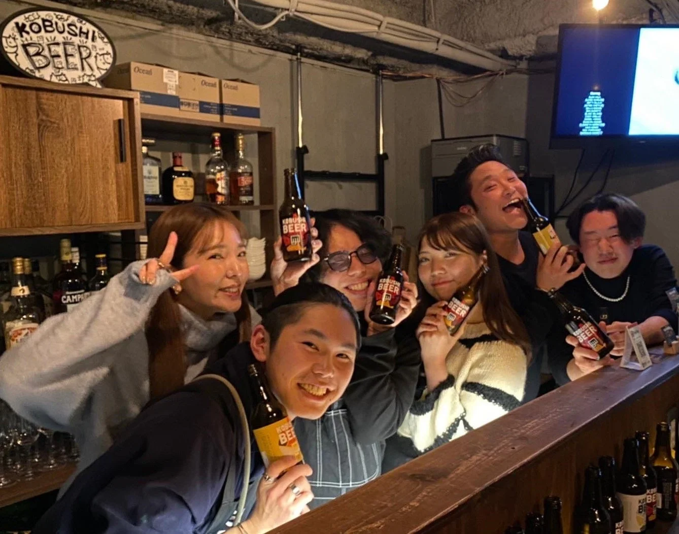バーカウンターに集まった人々がビールを楽しむ様子