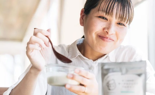 笑顔でヨーグルトを食べる女性
