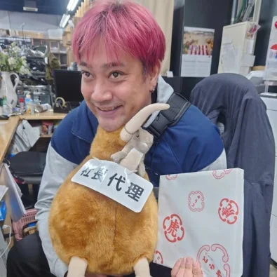 ピンク髪の男性とぬいぐるみ