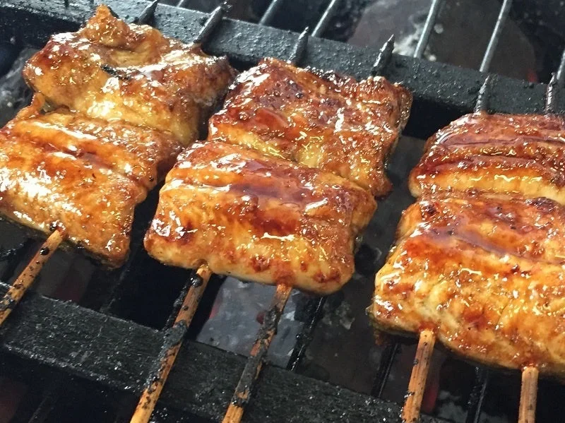炭火でじっくりと焼かれたうなぎの蒲焼の串が並んでいます。