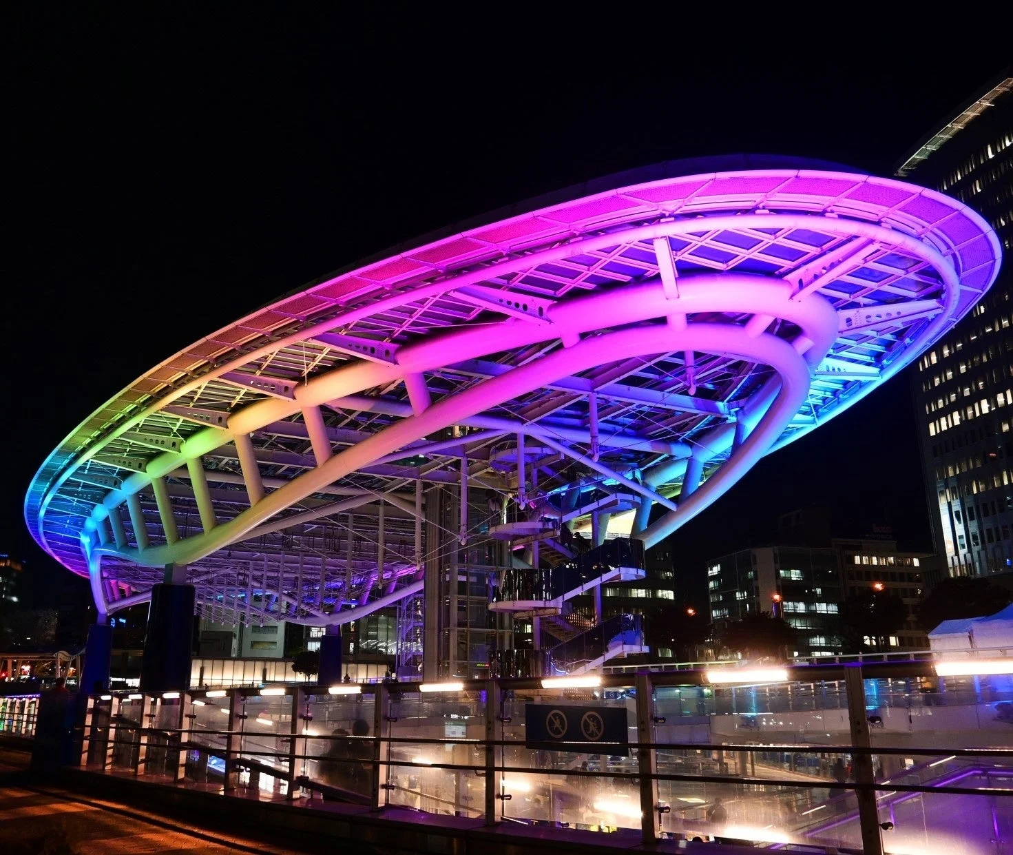 夜空に浮かぶ、楕円形の屋根が特徴的な近代的な建築物