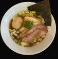 白い丼に盛り付けられた醤油ベースのラーメンです。鶏チャーシューと豚チャーシュー、味玉、ネギ、そして海苔がトッピングされています。