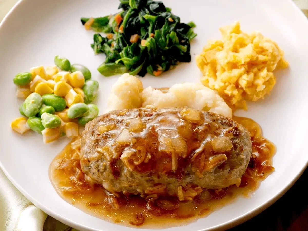 ハンバーグステーキに玉ねぎたっぷりのソースがかかったメインディッシュ