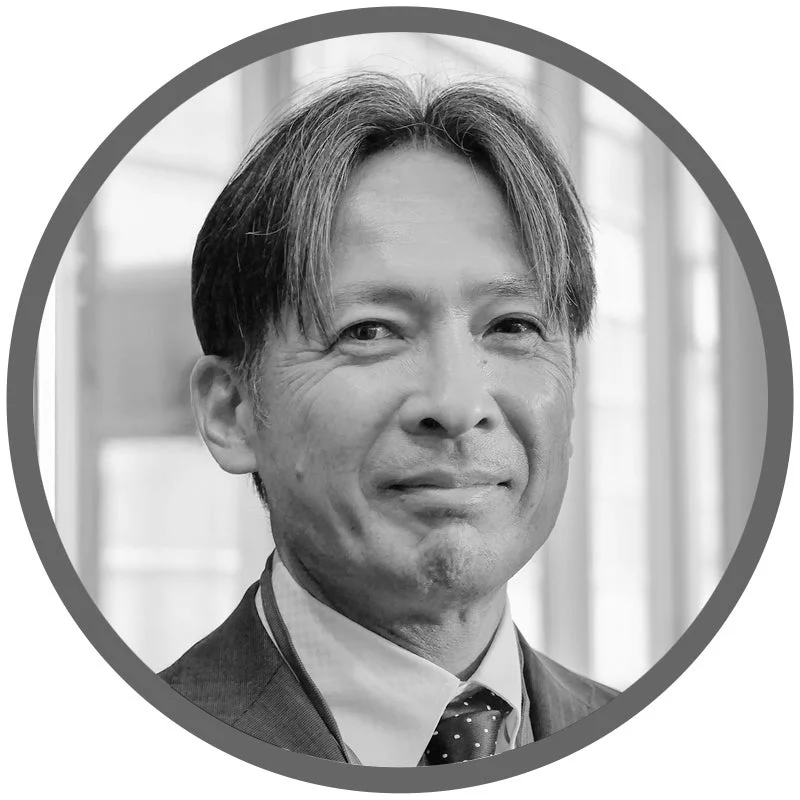 モノクロで撮影された、スーツとネクタイを着用したアジア系男性のバストアップポートレート