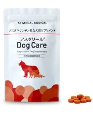 白いパッケージの犬用サプリメント「アスタリール Dog Care」と、そのオレンジ色の錠剤が写っています